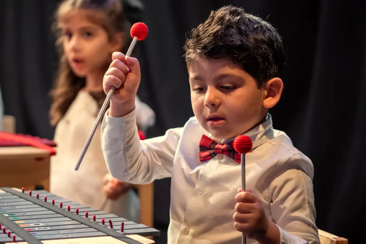A young boy playing xylophone in the Orff programme
