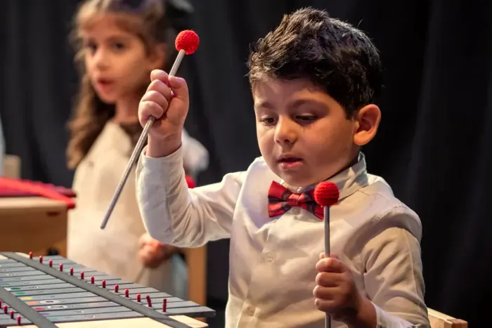 A young boy playing xylophone in the Orff programme