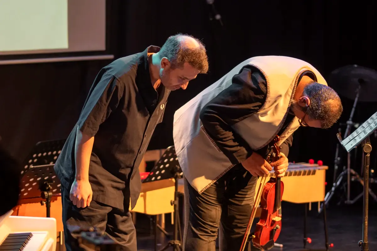 Two teachers bowing after a performance